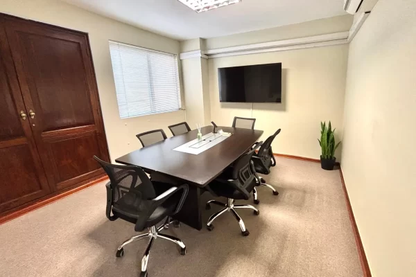 Sala de reuniones equipada en San Isidro con Smart TV, mesa de directorio y sillas ergonómicas — Lima Coworking